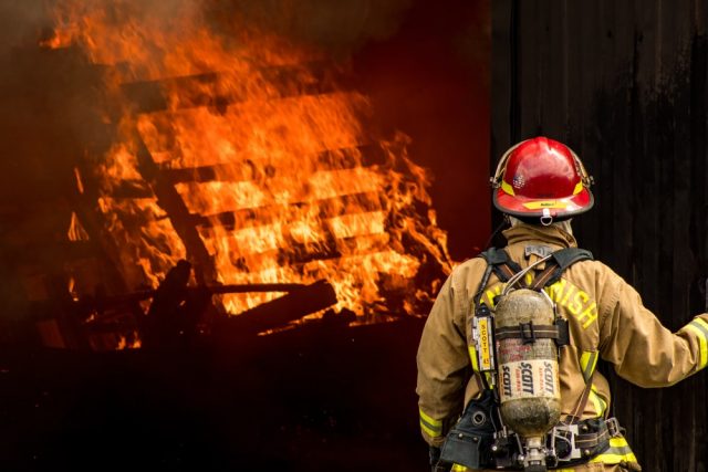 Fireman looking at burning house